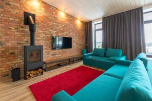 Modern living room featuring a stylish brick fireplace and vibrant turquoise sofas.